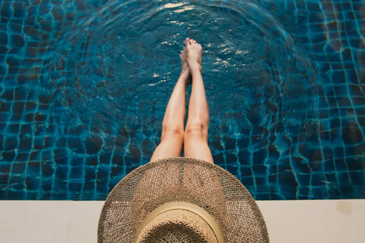 lady in hat by the pool edge
